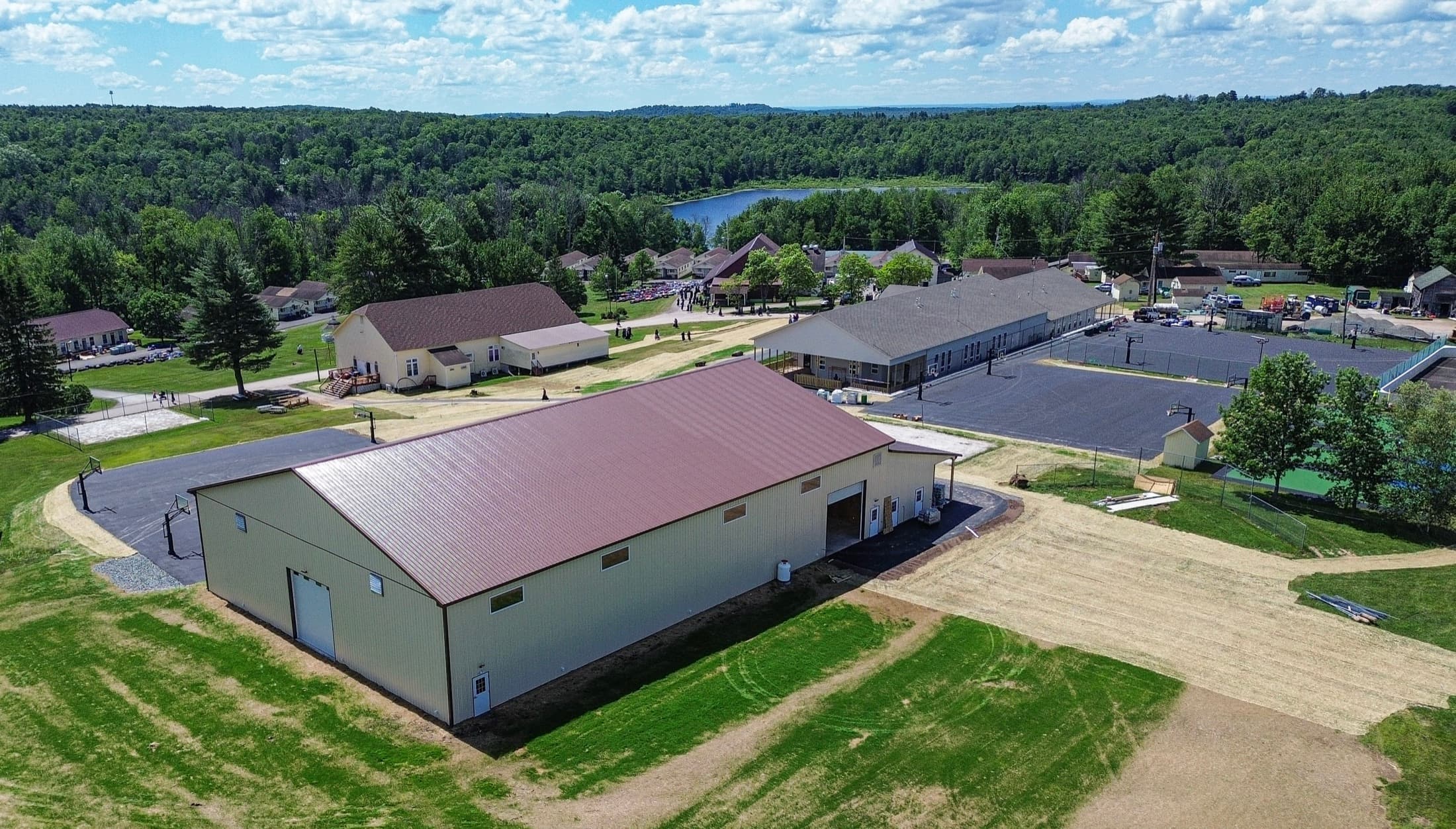 Aerial view of a completed recreation building with lake and woodland behind it