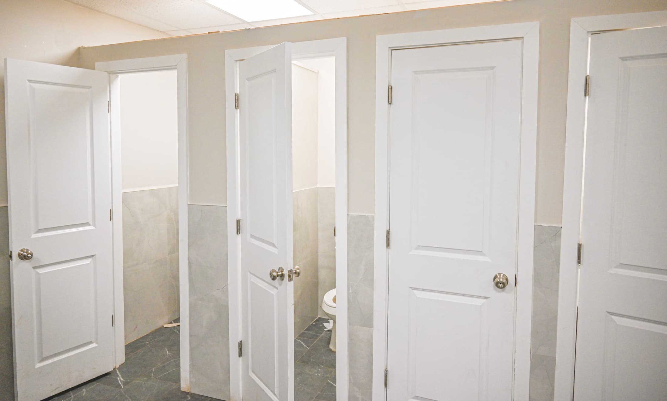Panelled washroom doors with tiled lower walls in a dormitory building