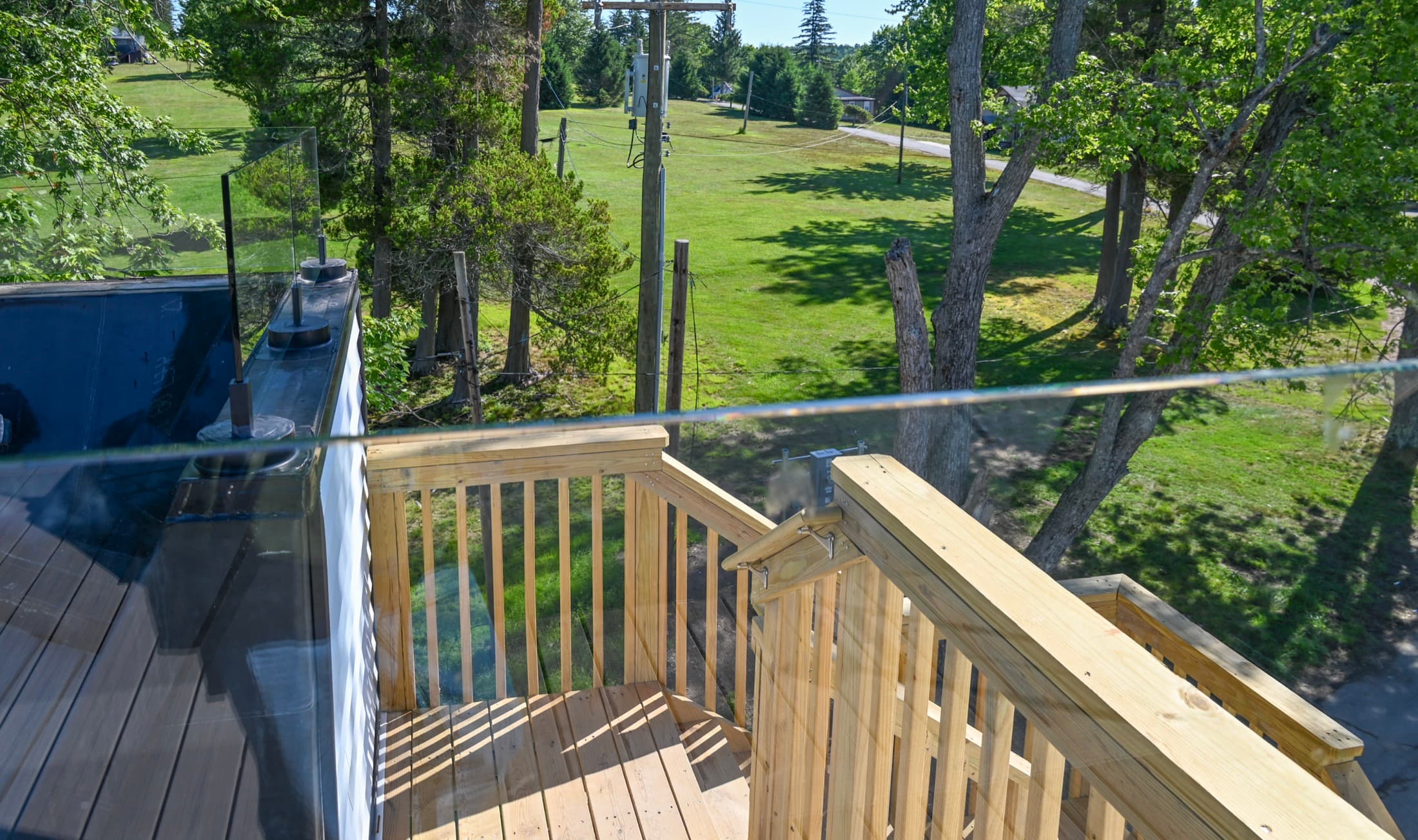 A roof deck under construction, new timber balustrade framed out above the campus below