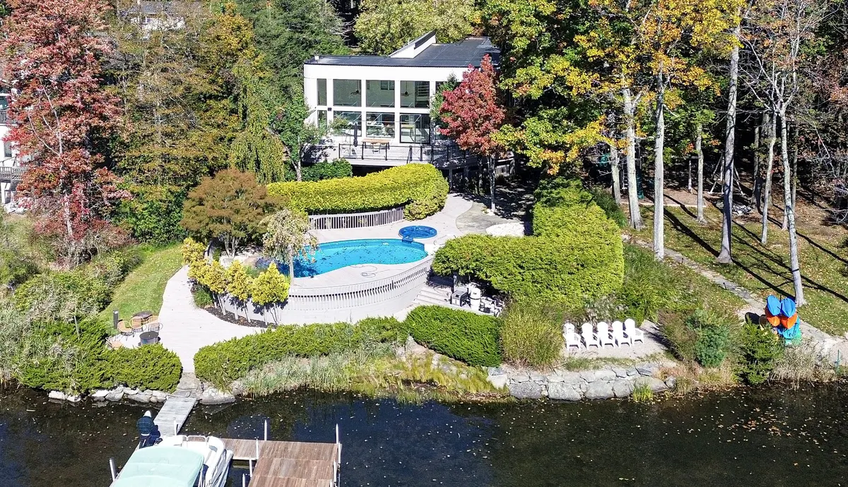 Completed lakefront home with landscaped grounds, a pool and deck